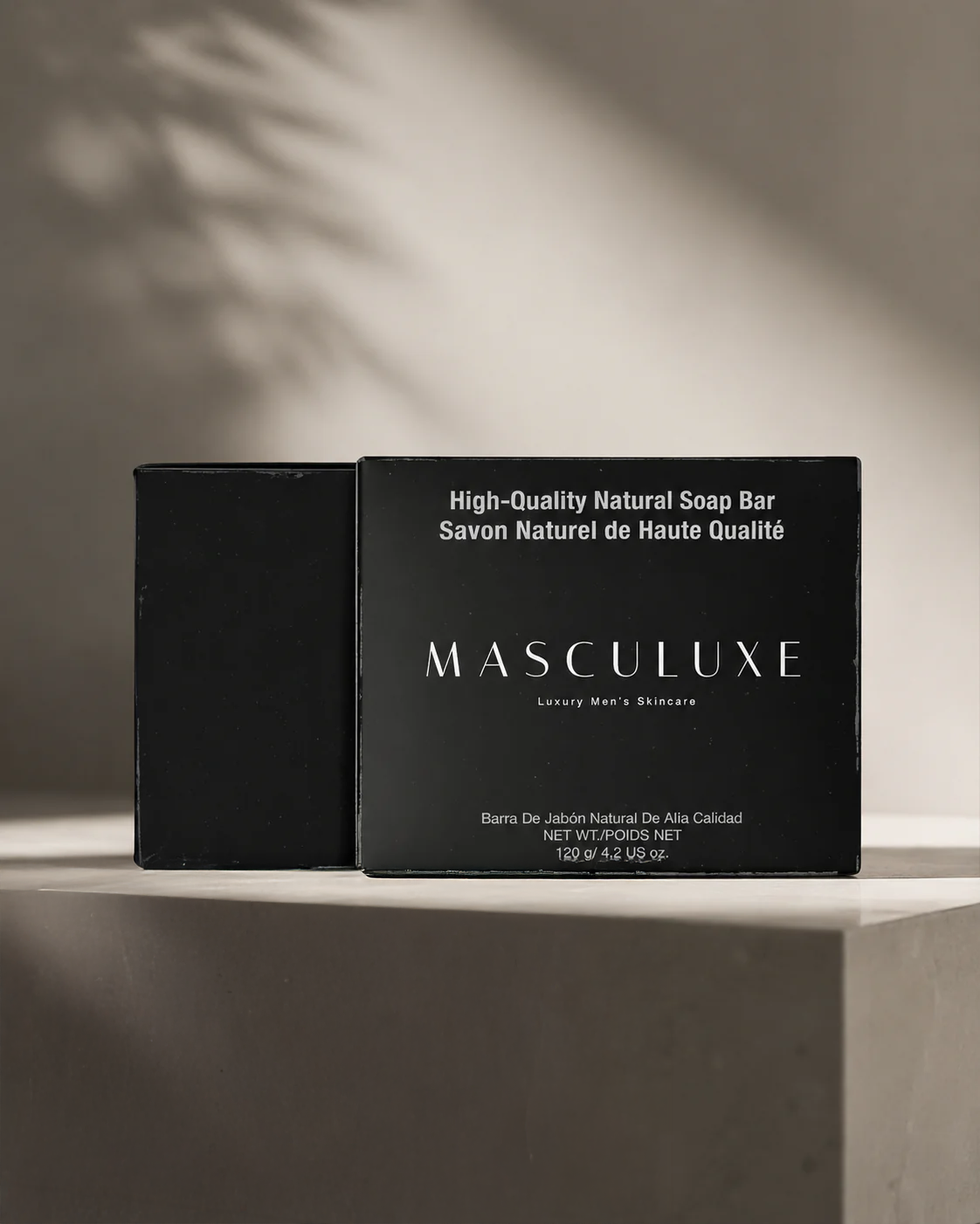 Black soap bar packaging with 'MASCULUXE' branding on a neutral background